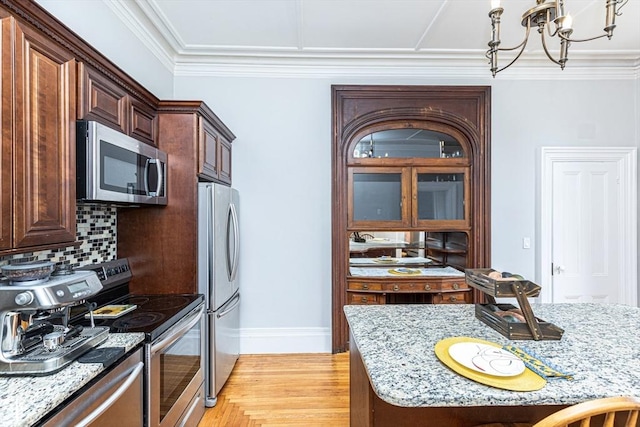 4 Mount Vernon Unit 1, Haverhill, MA 01830 - kitchen featuring appliances with stainless steel finishes, backsplash, light stone countertops, a chandelier, and light wood finished floors
