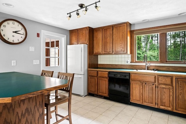 42 Howe St, Ipswich, MA 01938 - kitchen with freestanding refrigerator, black dishwasher, a sink, brown cabinets, and tasteful backsplash