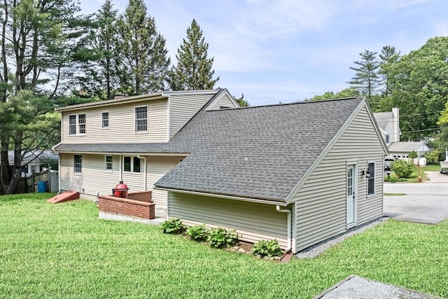42 Howe St, Ipswich, MA 01938 - rear view of house with a shingled roof, a chimney, and a lawn