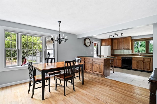 42 Howe St, Ipswich, MA 01938 - dining space featuring a chandelier, light wood finished floors, baseboards, and track lighting