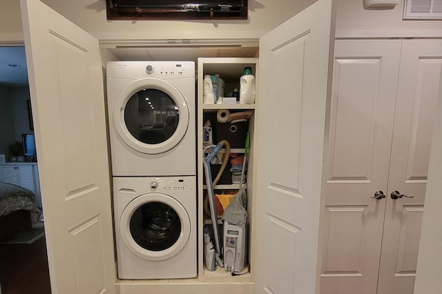 laundry area featuring laundry area, stacked washer / dryer, and visible vents