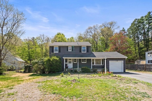 207 E Central, Natick, MA 01760 - traditional-style home featuring covered porch, aphalt driveway, fence, a front lawn, and an attached garage