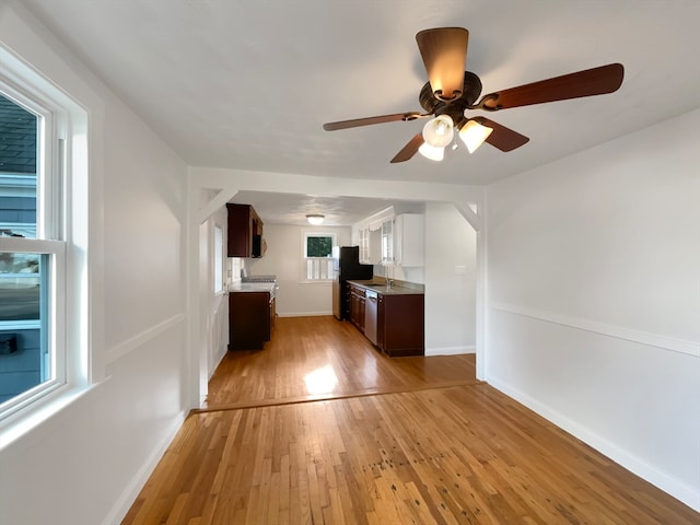 unfurnished living room with ceiling fan and light wood-type flooring