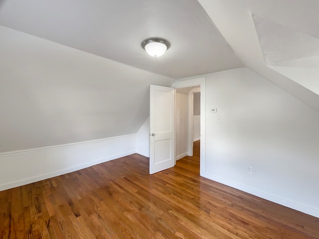 additional living space featuring vaulted ceiling and hardwood / wood-style flooring