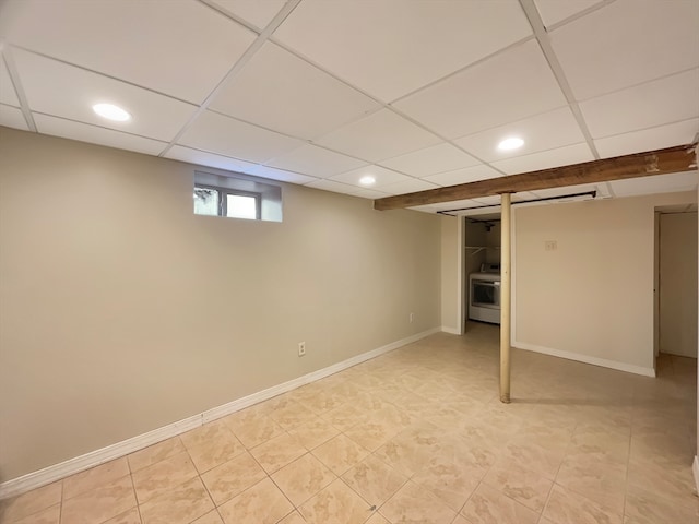 basement featuring light tile patterned floors, a paneled ceiling, and washer / clothes dryer