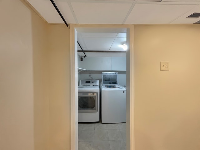 laundry area with washer and dryer and light tile patterned floors