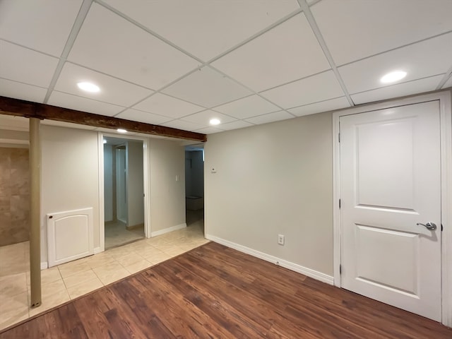 basement featuring hardwood / wood-style flooring and a drop ceiling