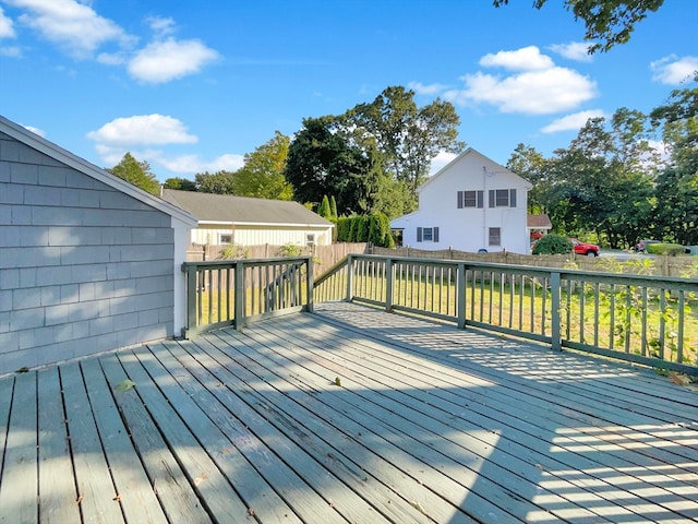 wooden deck featuring a lawn