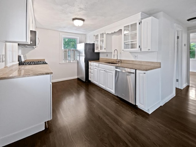 444 Lowell St, Reading, MA 01867 - kitchen with stainless steel appliances, a sink, dark wood-type flooring, and baseboards