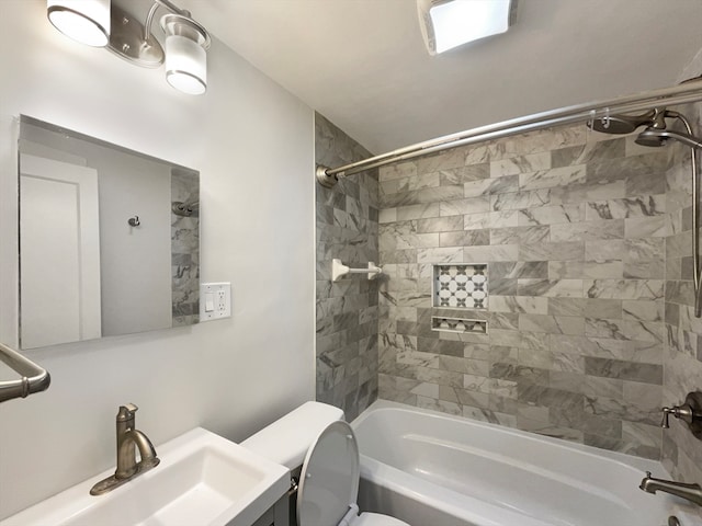 full bathroom with tiled shower / bath, vanity, and toilet