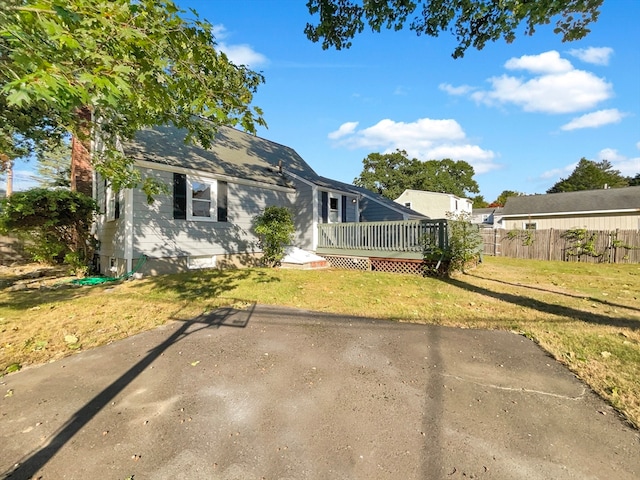 view of front of home featuring a front yard and a wooden deck