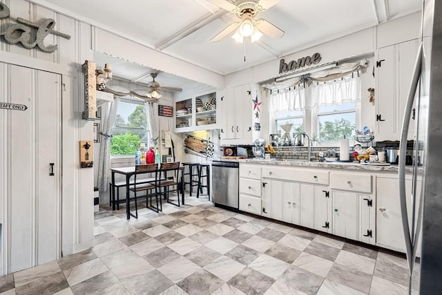 kitchen featuring stainless steel appliances, ceiling fan, white cabinetry, light countertops, and a sink