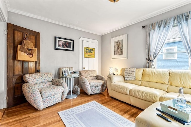 living area with crown molding and light wood-style floors