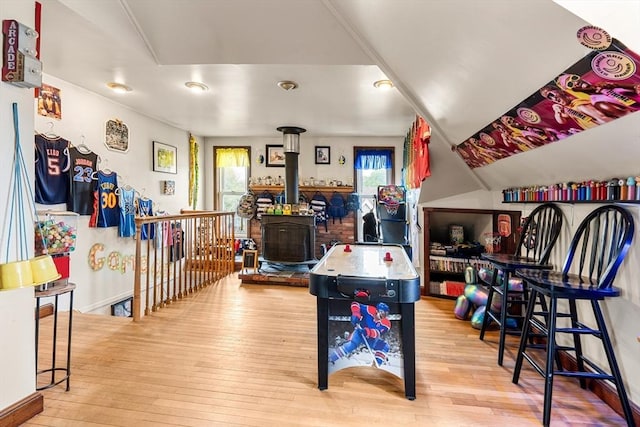 recreation room with wood-type flooring and a wood stove