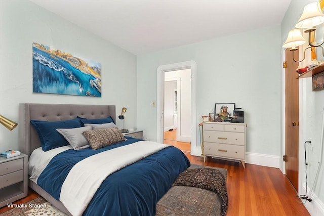 bedroom with wood finished floors and baseboards