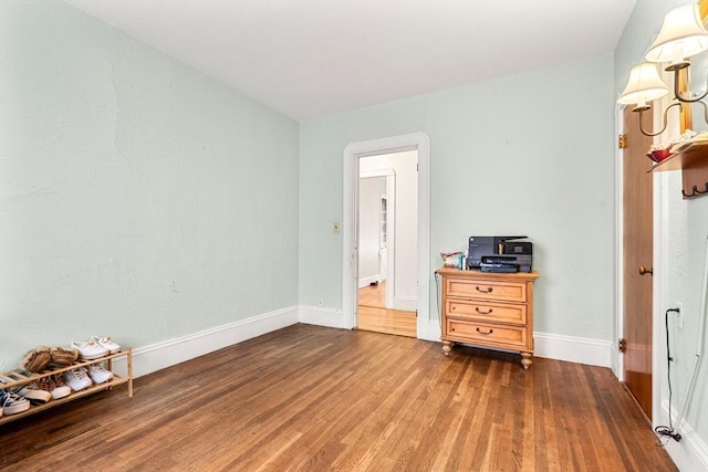 bedroom with wood finished floors and baseboards