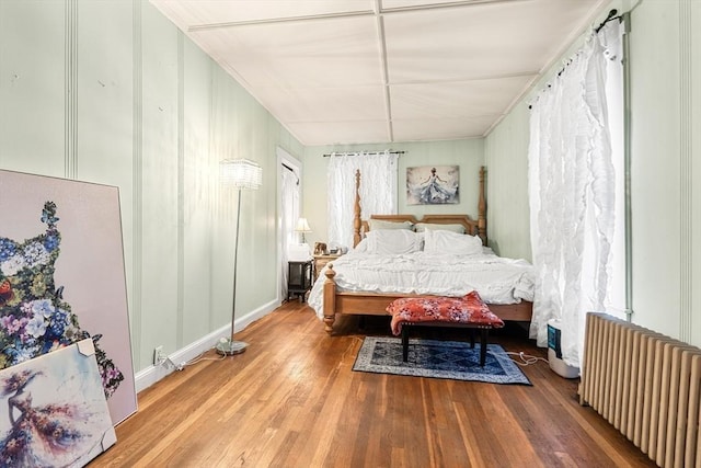 bedroom with radiator and wood finished floors
