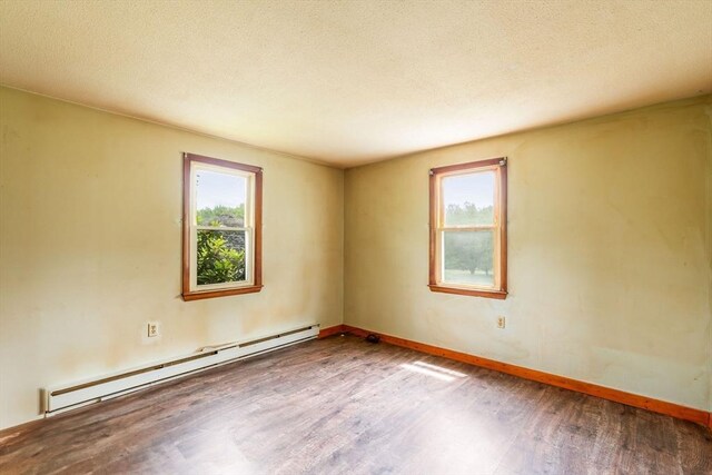 79 Chapel St, Gardner, MA 01440 - spare room featuring a baseboard heating unit, wood finished floors, healthy amount of natural light, and a textured ceiling