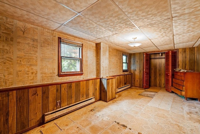 79 Chapel St, Gardner, MA 01440 - unfurnished room featuring a baseboard heating unit, wooden walls, and a paneled ceiling