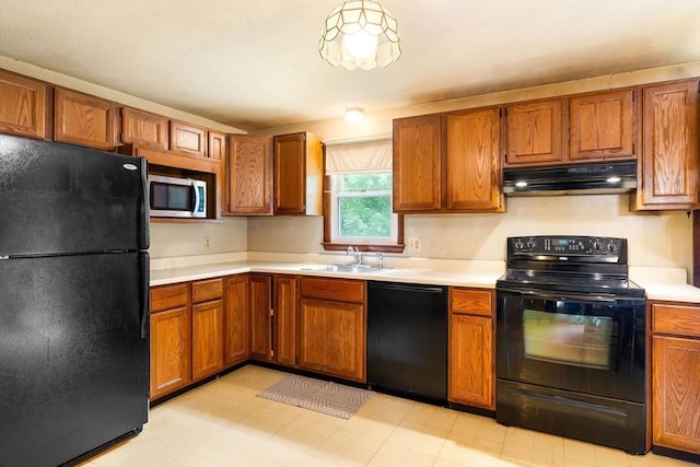 79 Chapel St, Gardner, MA 01440 - kitchen with black appliances, under cabinet range hood, light countertops, and brown cabinetry