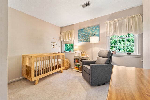 carpeted bedroom featuring a crib