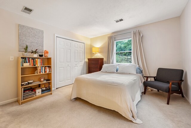 bedroom featuring light carpet and a closet