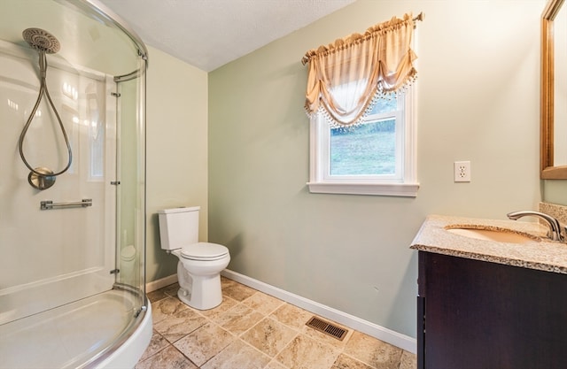 bathroom featuring walk in shower, vanity, toilet, and a textured ceiling