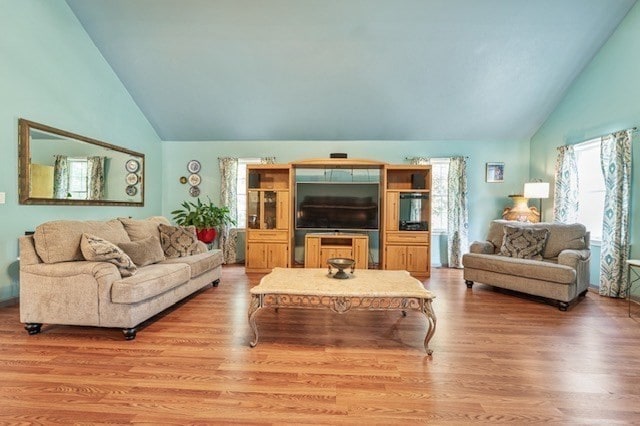 living room featuring light hardwood / wood-style flooring and high vaulted ceiling