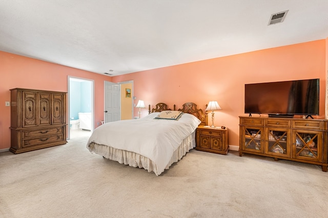 bedroom featuring light colored carpet and connected bathroom