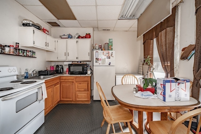 kitchen featuring white cabinets, a drop ceiling, white appliances, and sink