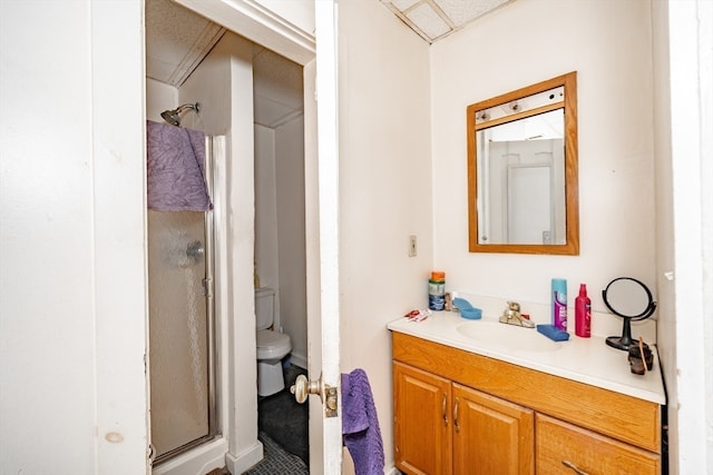 bathroom with vanity, toilet, and a shower with door