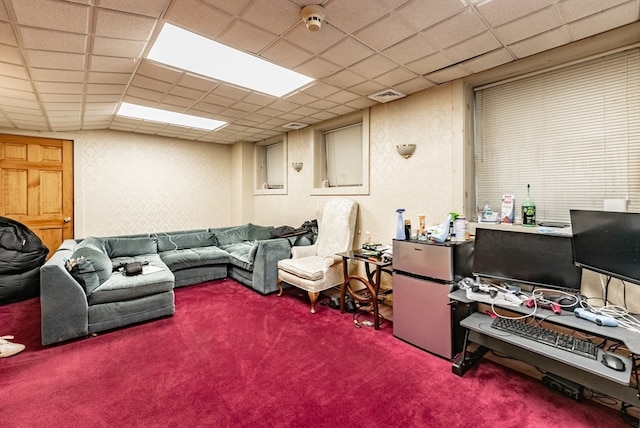 living room featuring carpet and a paneled ceiling