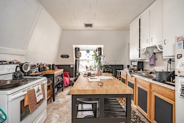 kitchen with white cabinets, white electric range, and backsplash