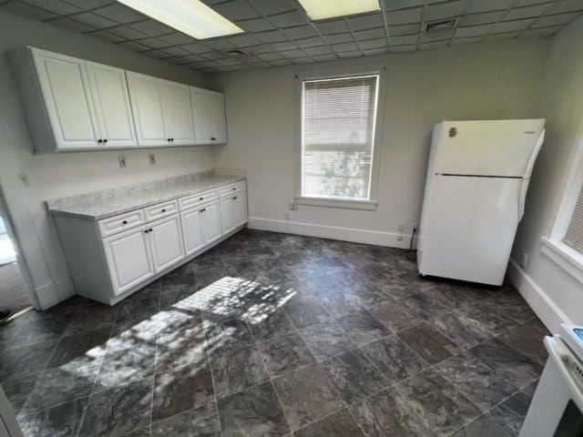 kitchen featuring a paneled ceiling, white cabinetry, and white fridge