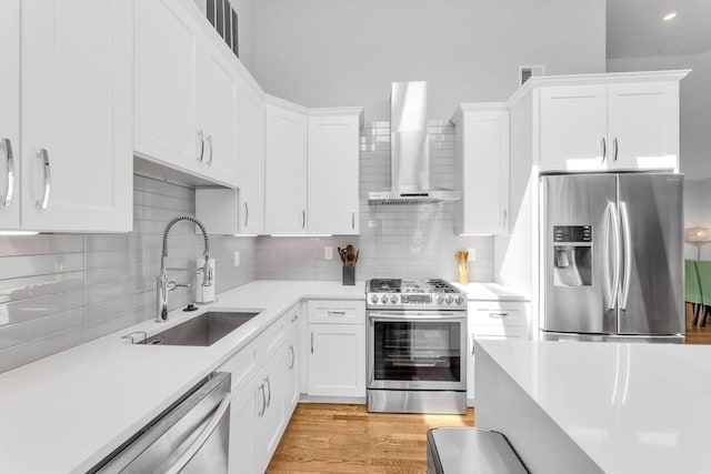 72 Rawson Rd Unit 2, Arlington, MA 02474 - kitchen with stainless steel appliances, wall chimney exhaust hood, a sink, and light countertops