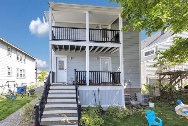 72 Rawson Rd Unit 2, Arlington, MA 02474 - view of front facade featuring a balcony, cooling unit, covered porch, and stairs