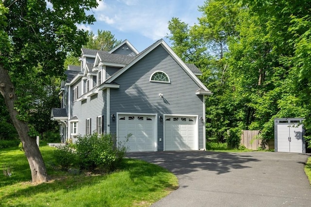 16 Border Rd, Reading, MA 01867 - view of property exterior featuring driveway, roof with shingles, and an attached garage