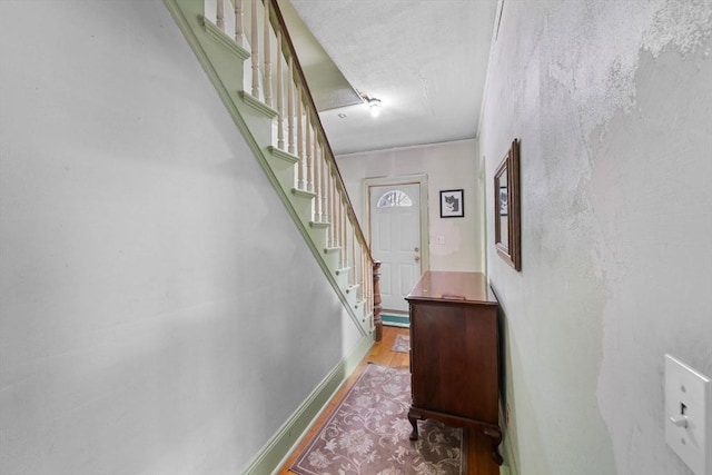 interior space with light wood-style flooring, baseboards, and stairs