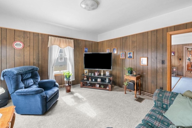 carpeted living room featuring wooden walls