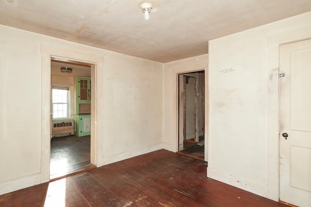 unfurnished room with radiator heating unit and dark wood-type flooring