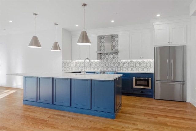 kitchen with white cabinets, decorative backsplash, stainless steel fridge, and hanging light fixtures