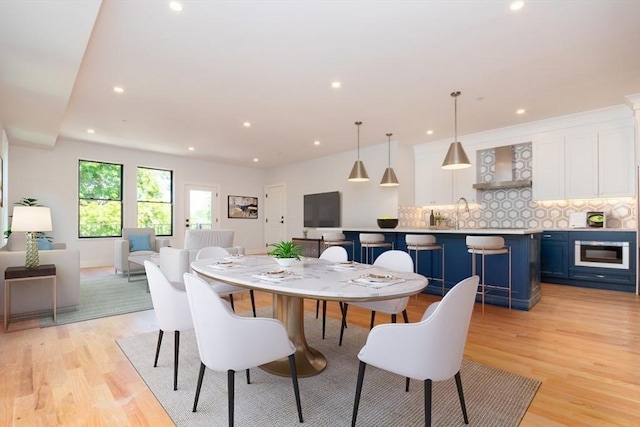 dining area with sink and light hardwood / wood-style flooring