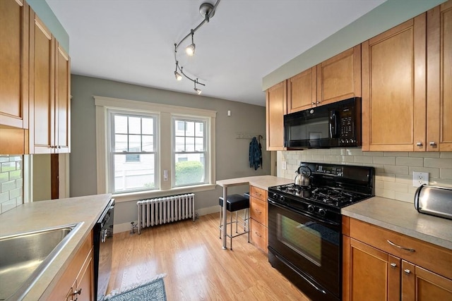 149 Milton Ave, Boston, MA 02124 - kitchen featuring black appliances, radiator, tasteful backsplash, baseboards, and light wood-type flooring