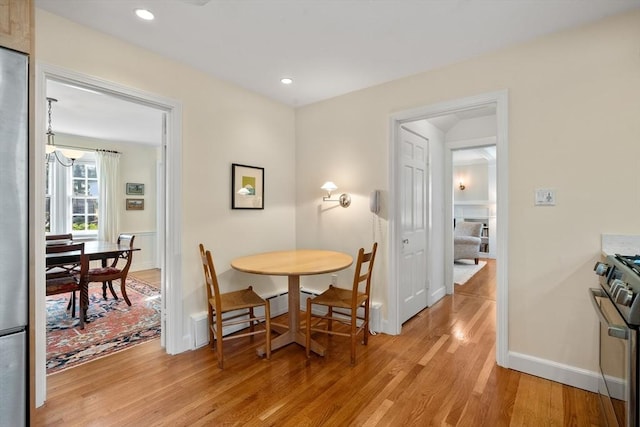 dining room with recessed lighting, baseboards, and light wood-style floors