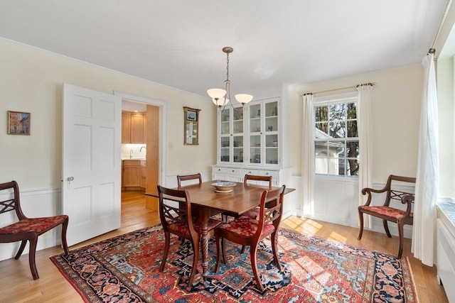 dining space with light wood finished floors and a notable chandelier