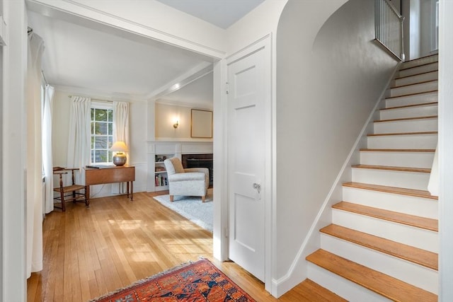 staircase with a fireplace and hardwood / wood-style floors
