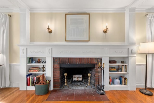 details with crown molding, a wainscoted wall, a fireplace, and wood finished floors