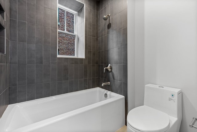 bathroom with toilet and tiled shower / bath