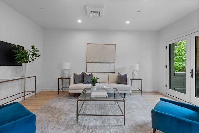 living room featuring french doors and light hardwood / wood-style flooring