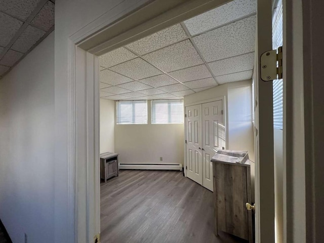 additional living space featuring light hardwood / wood-style floors and a baseboard heating unit